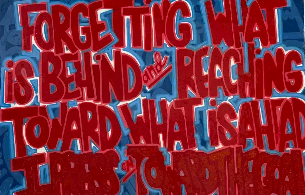 A red and blue painting at NinjaFit that reads: Forgetting what is behind and reaching toward what is ahead, I press on toward the goal